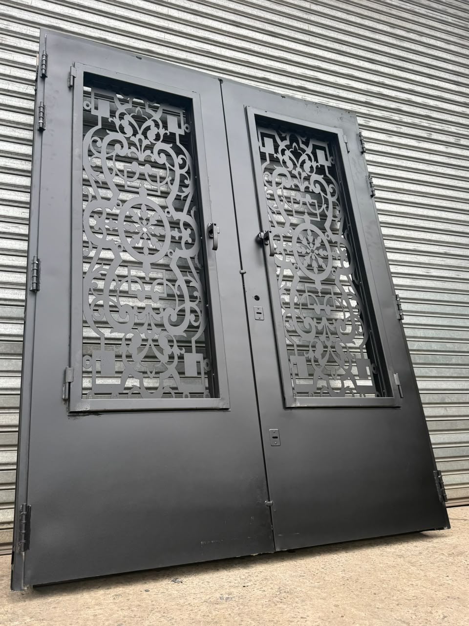 Puerta doble de hierro con celosía calada vista lateral — San Vicente, Zona Sur